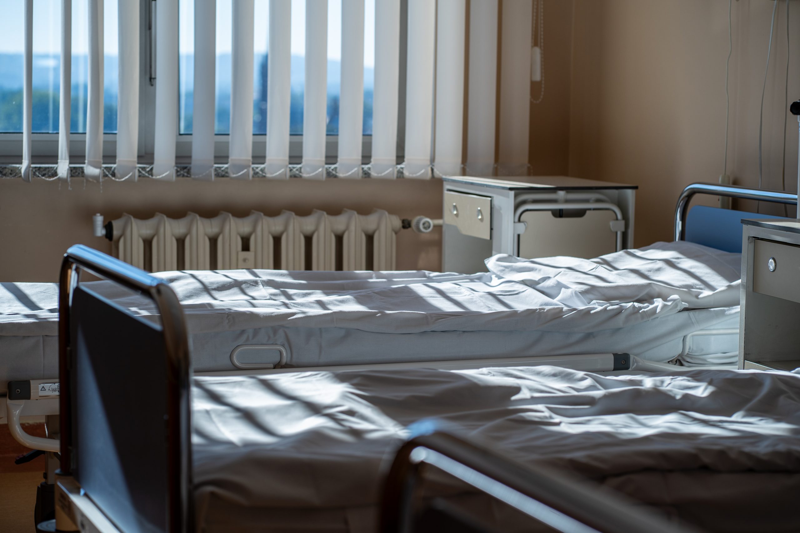 Multiple,Empty,Hospital,Beds,With,Clean,Sheets,Lit,By,Morning
